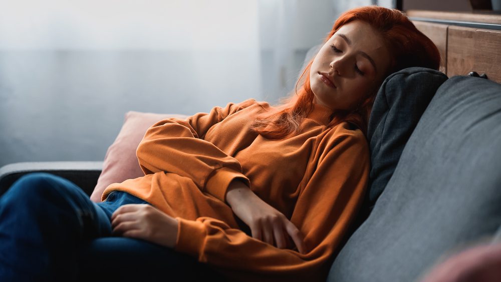 a teen girl sleeping on the sofa
